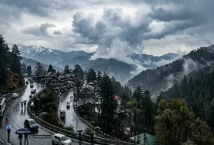 हिमाचल प्रदेश में बारिश और बादलों से घिरा पहाड़ी शहर का दृश्य